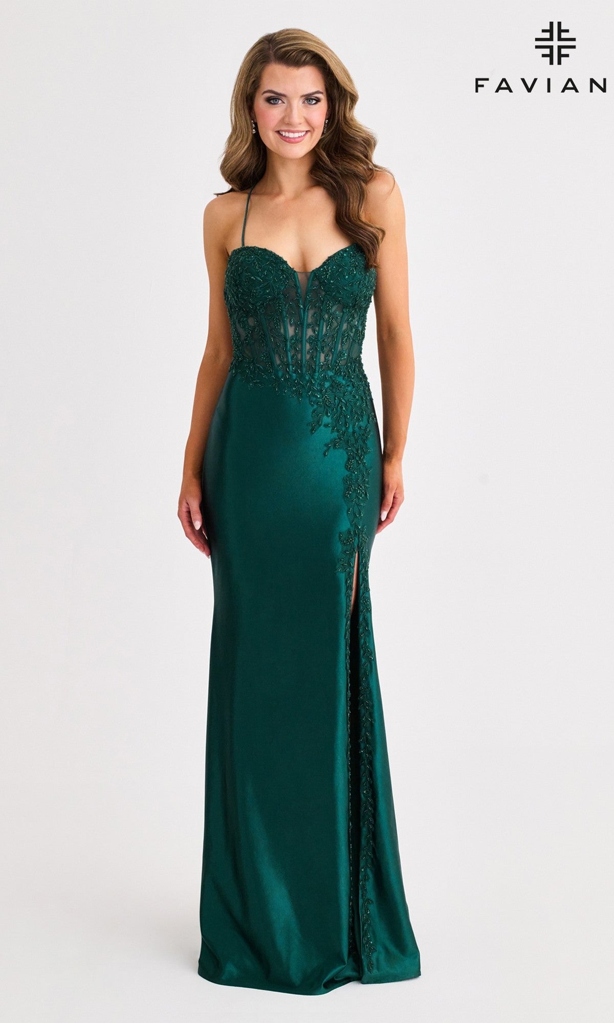 A woman wears the Faviana 11404 long prom dress in dark green satin, featuring lace details, a sweetheart neckline, corset bodice, high slit, and strappy open back, standing against a plain background.